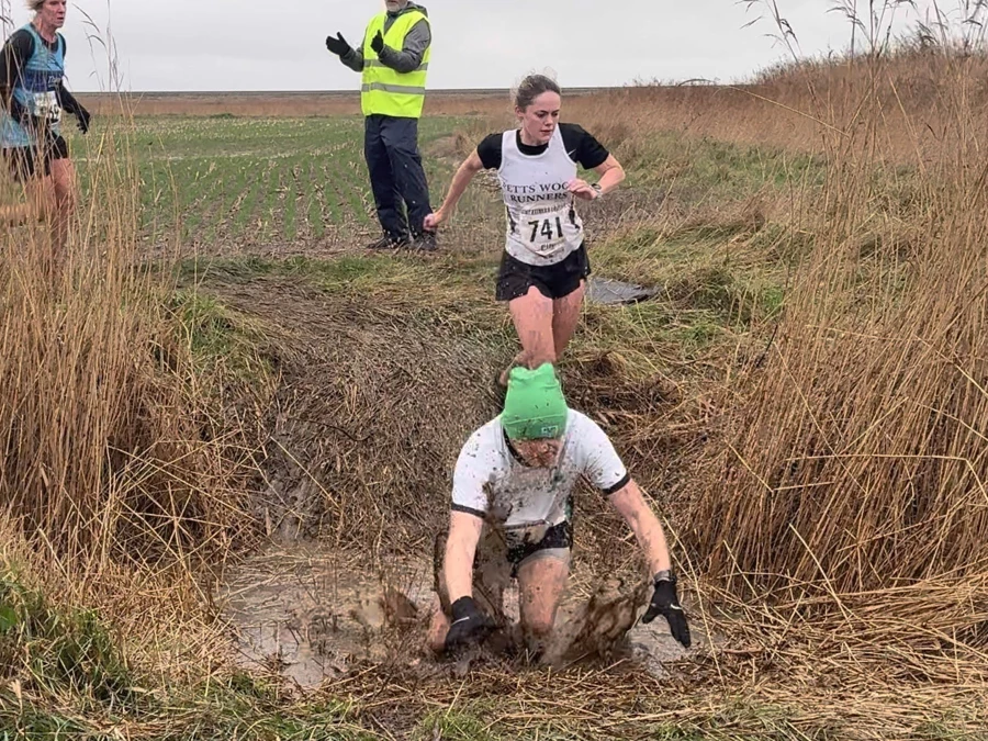 KFL Minnis Bay 2024 - Kent Fitness League runners in action crossing a muddy ditch. Martin Jones of Maidstone Harriers