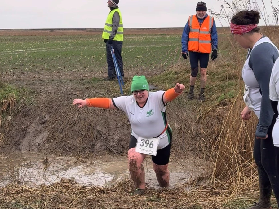KFL Minnis Bay 2024 - Kent Fitness League runners in action. Catey Bowles of Maidstone Harriers crossing a muddy dyke.