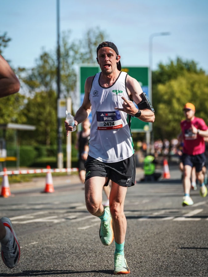 Phil Edmonds racing on the road in a Maidstone Harriers club vest.