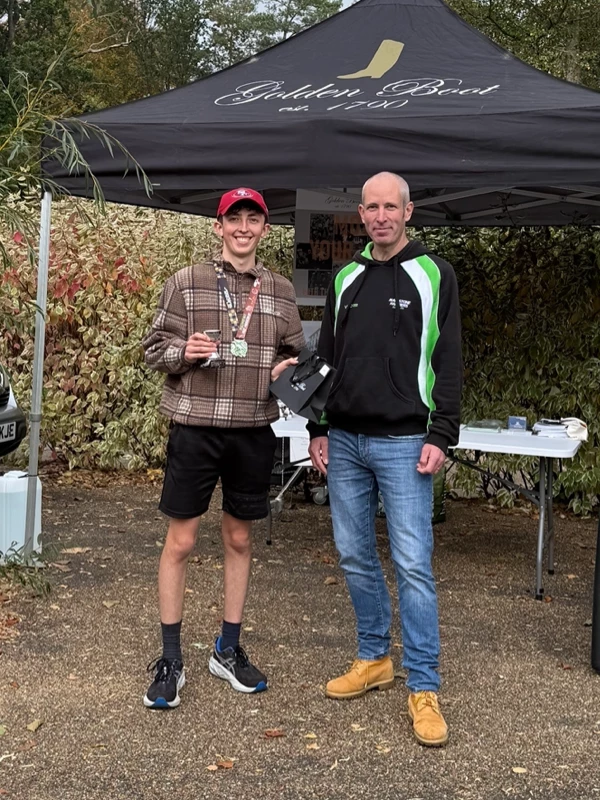 Maidstone Half Marathon medalist, Sam Flood, getting their trophy in the 2025 event. Hosted by the Maidstone Harriers Run and Tri Club