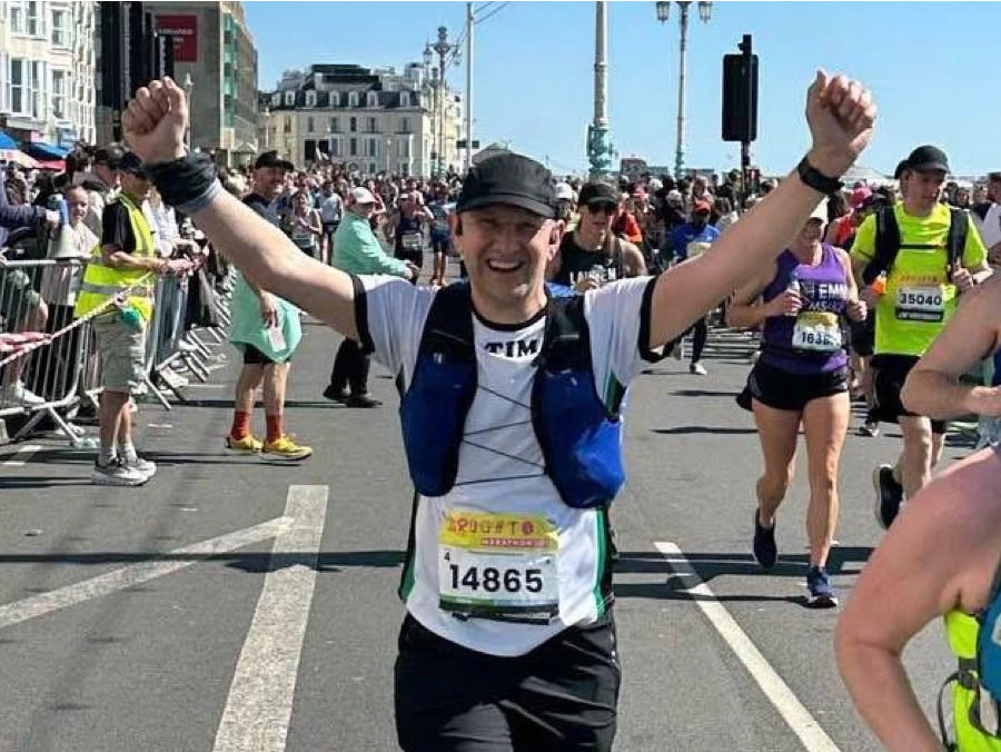 Tim Hilder of Maidstone Harriers celebrates finishing the Brighton Marathon with arms raised