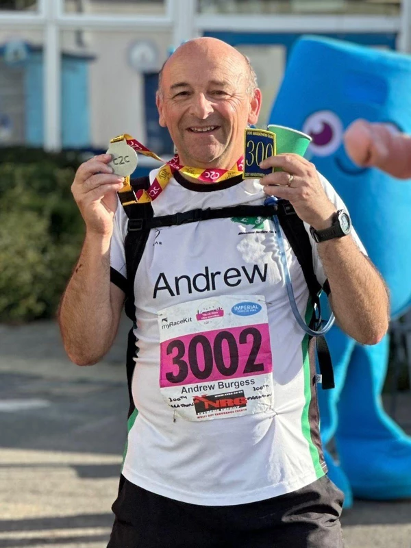 Maidstone Harriers runner Andrew Burgess holding his c2c medal and 300th marathon memento after the c2c Railway Ultra in September 2025