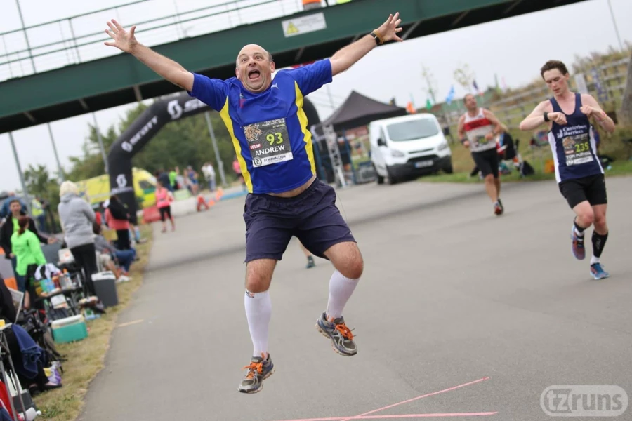 Maidstone Harriers runner Andrew Burgess striking an excited star jump-style pose during the Kent Coyote Marathon in 2016