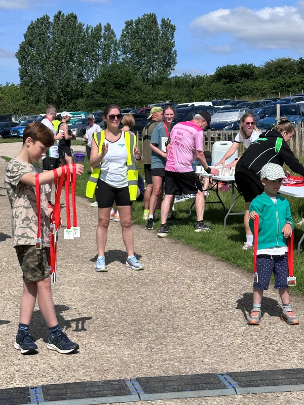 Volunteers handing out finishers medals at the finish area at the 2026 Maidstone Harriers David Thornby 10k.