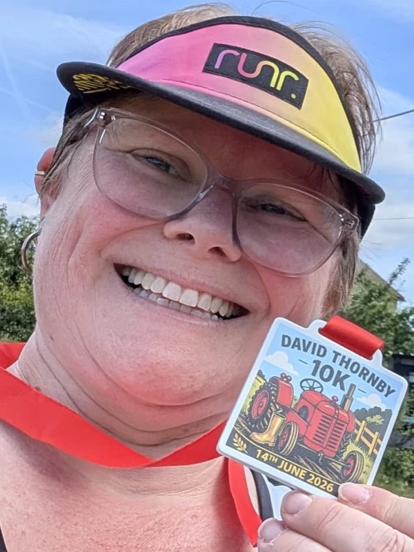 Maidstone Harriers' Catey Bowles smiling with her David Thornby 10K 2026 medal