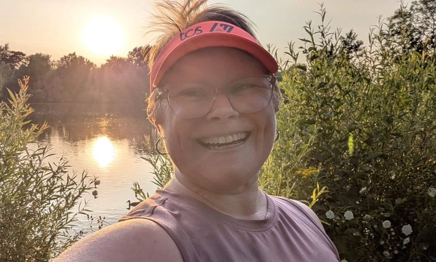 Maidstone Harriers' Catey Bowles smiling beside a lake after open water swimming