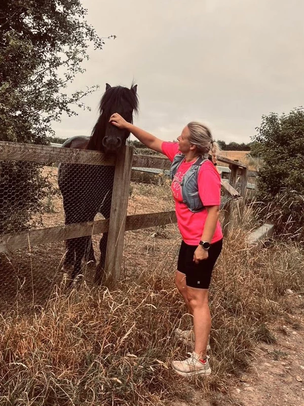 Maidstone Harriers runner Jo Smit greeting a horse during a trail run